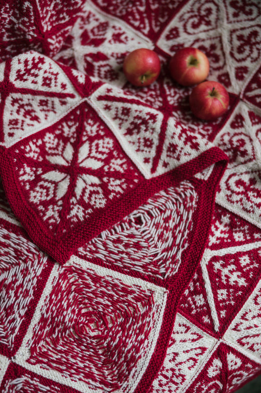 Gebreide kerstdeken Jouluntähti in rood en wit met Scandinavisch kleurwerk, gebreid met Novita Nalle wol